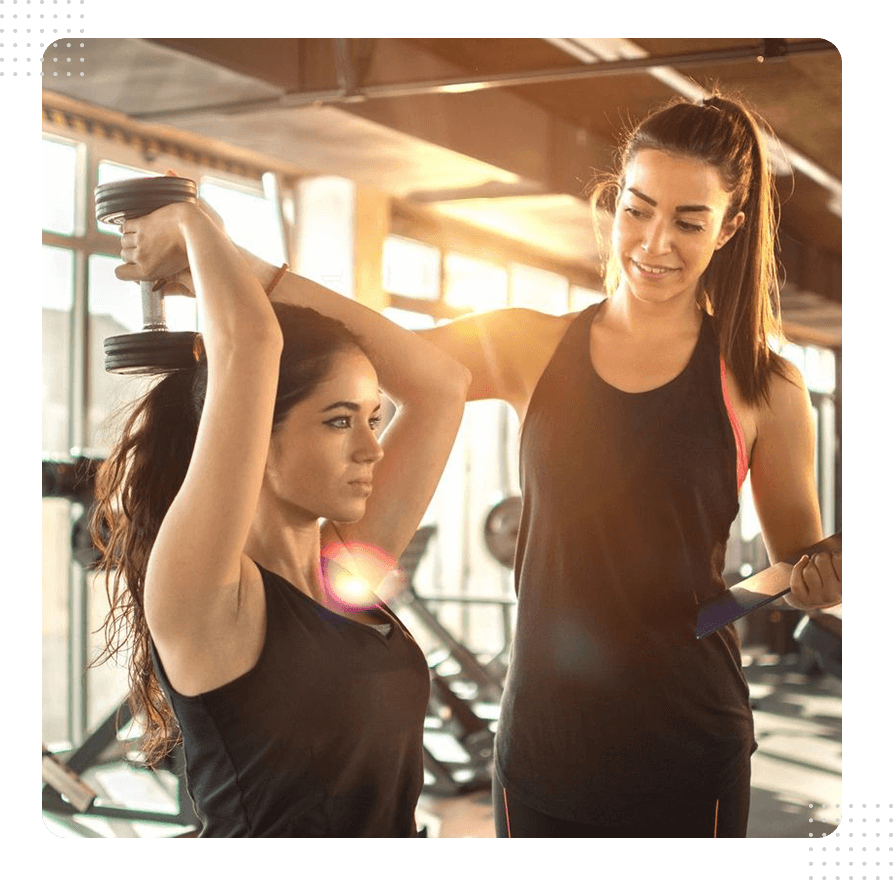 Two women are working out together in a gym.